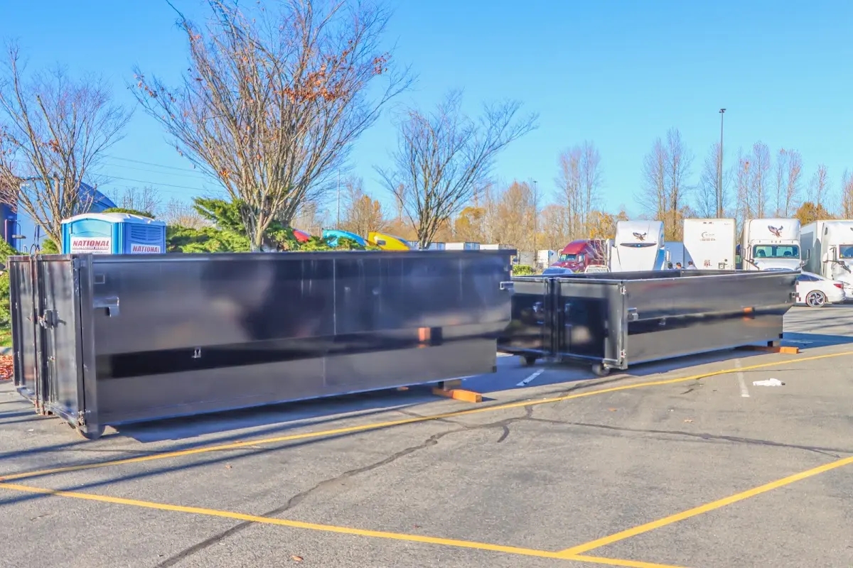 Professional dumpster rental service with roll-off container on residential driveway in Myrtle Grove